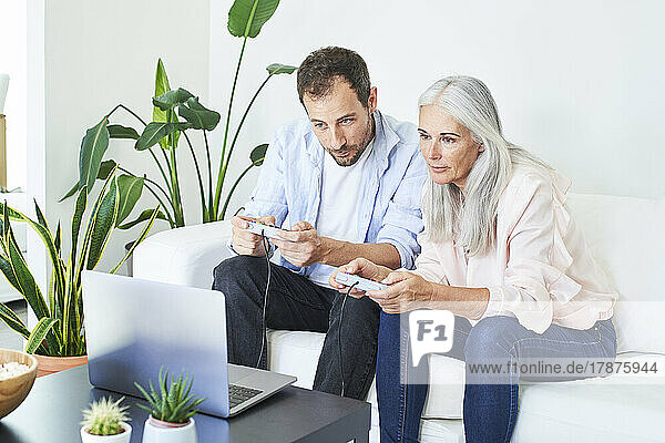 Mature woman with son playing video game at home
