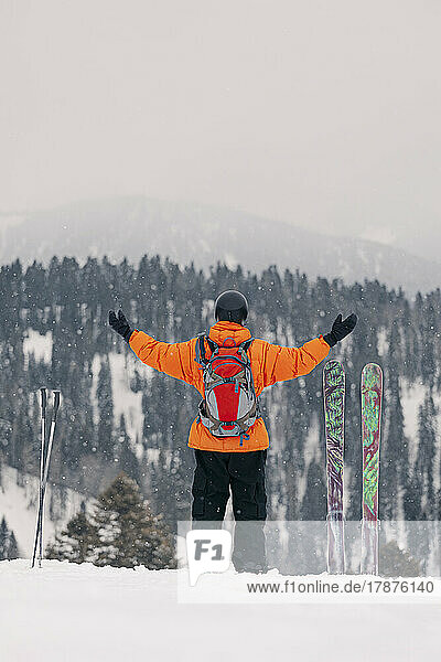 Skier standing with arms outstretched standing on snow