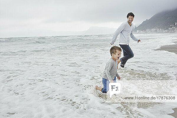 Father running on the beach with his son