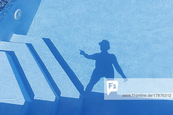 Shadow of man seen on water of swimming pool