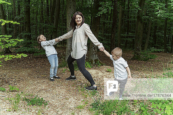 Mother with son and daughter playing in forest