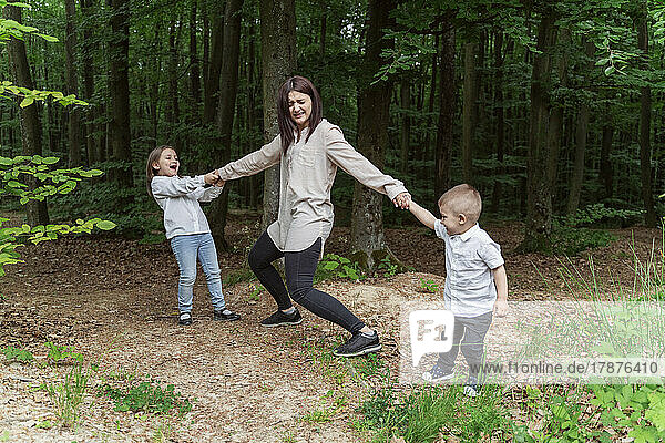 Children playing with mother in forest