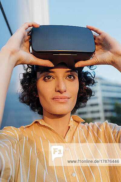 Nachdenkliche Frau mit Virtual-Reality-Headset