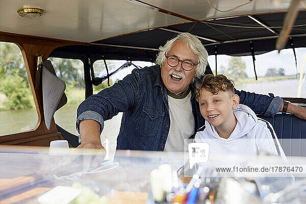 Excited senior man with grandson in boat