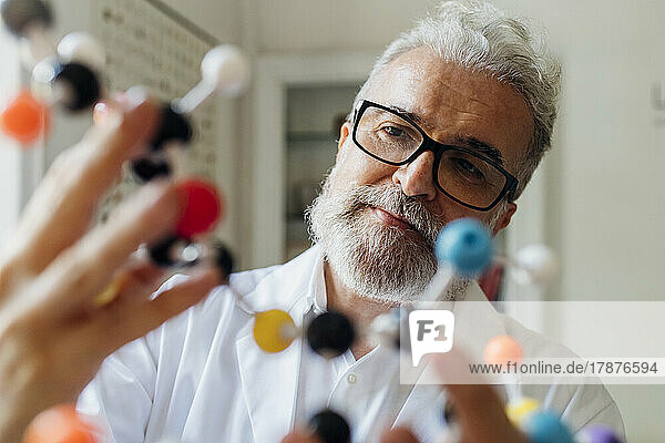 Scientist wearing eyeglasses looking at molecular structure