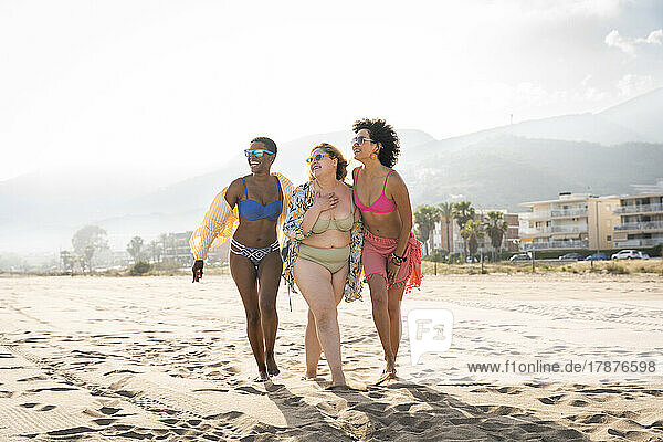 Multiracial friends walking at beach