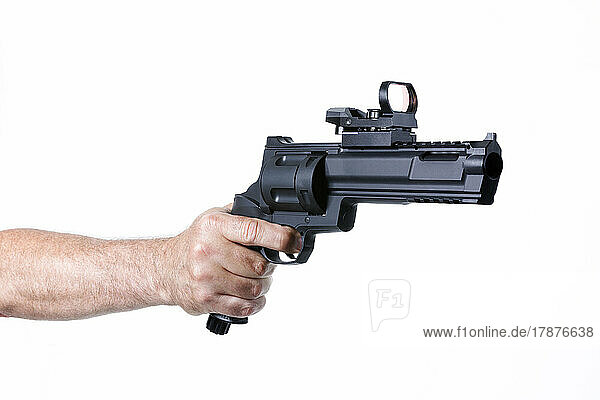 Hand of man shooting with revolver against white background