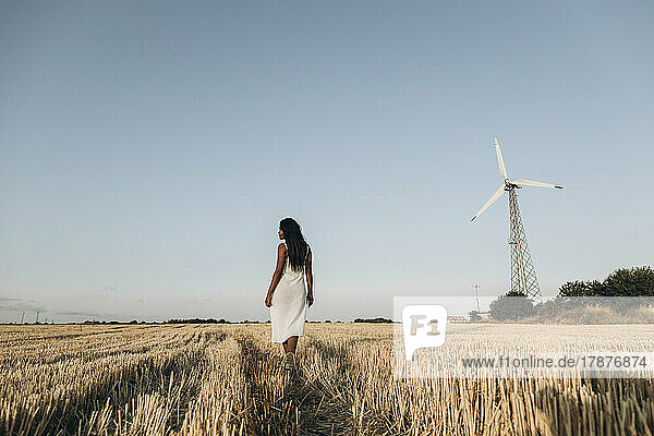 Woman at wheat farm in front of sky