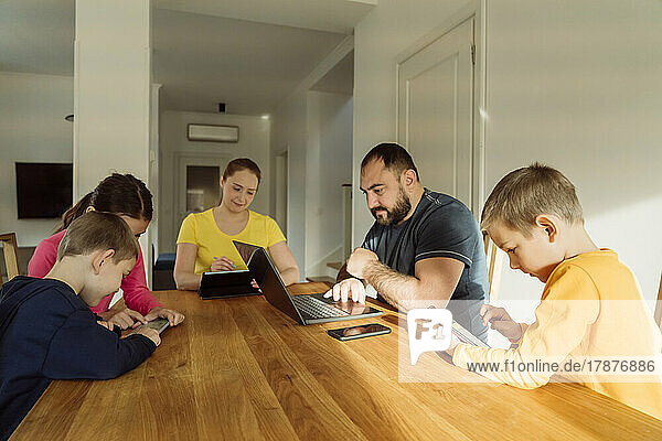 Familie nutzt drahtlose Technologien auf dem heimischen Tisch