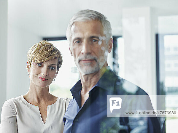 Smiling businesswoman with businessman in office