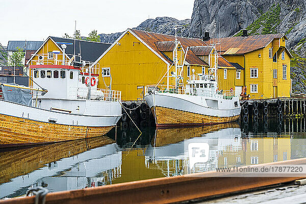 Norway  Nordland  Nusfjord  Fishing boats moored in front of coastal stilt houses