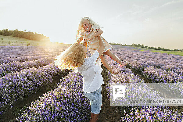 Playful mother enjoying with daughter in lavender field
