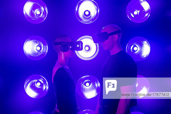 Couple wearing VR glasses by neon lights