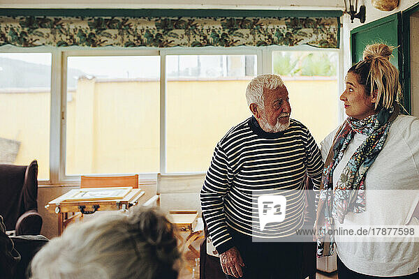 Älterer Mann und Frau stehen zu Hause