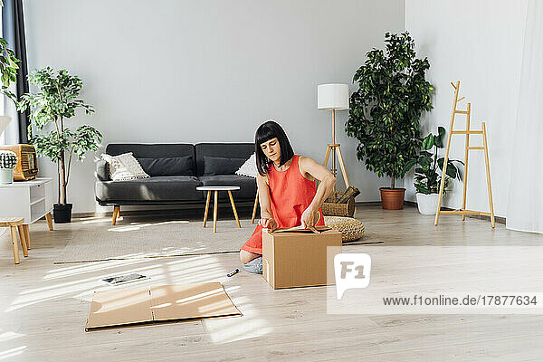 Woman at home packing boxes at home