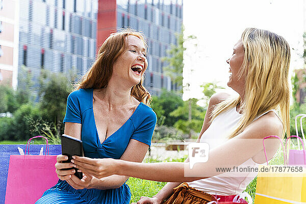 Friends laughing with smart phone in hand