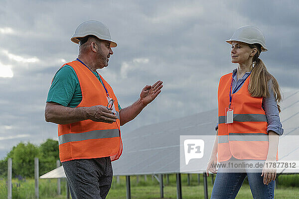 Engineer discussing with coworker at solar station