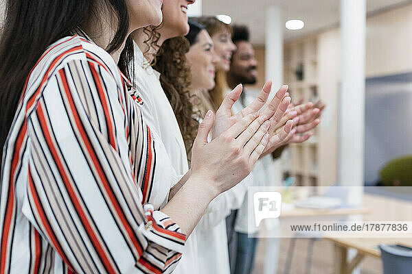 Business team clapping hands after a presentation in office