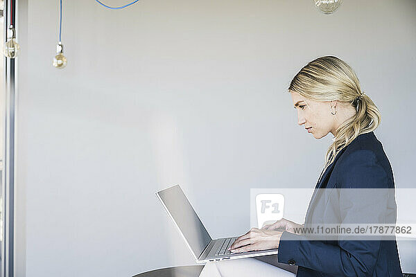 Blonde Geschäftsfrau benutzt Laptop im Büro