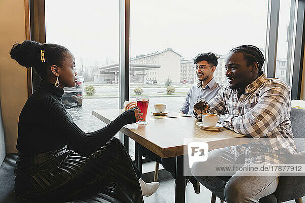 Gemischtrassige Freunde verbringen Zeit miteinander im Café