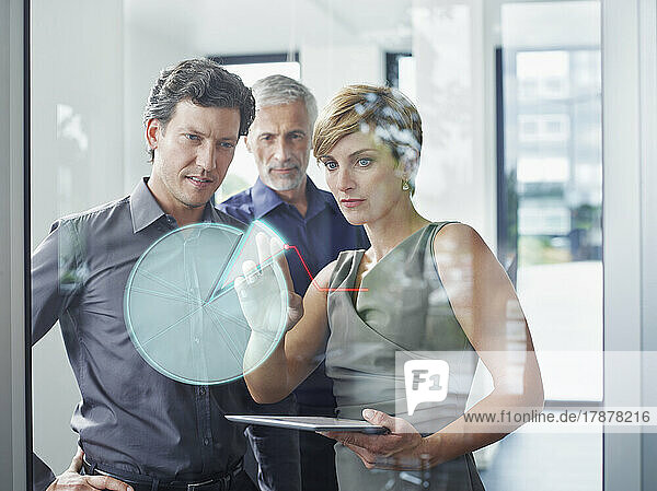 Businesswoman with colleagues discussing augmented pie chart