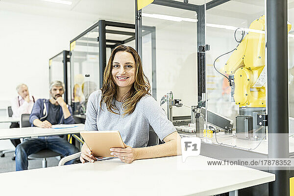 Woman working in robotic factory using digital tablet