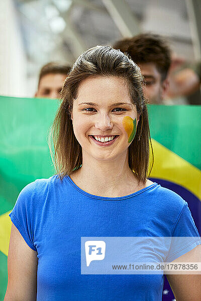 Smiling woman with Brazil Flag painted on face