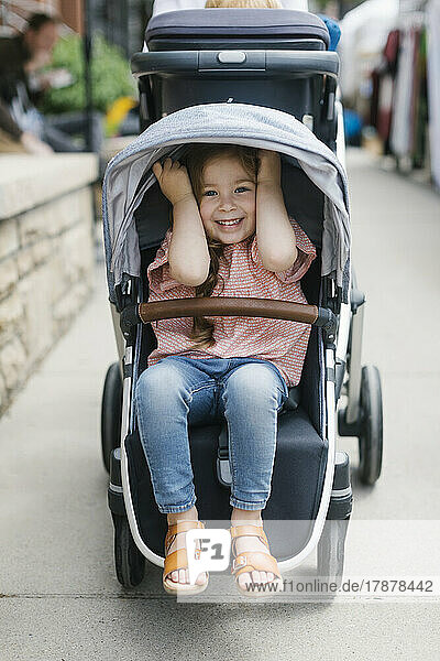 Smiling girl (2-3) in stroller