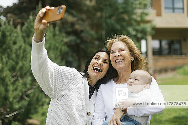 Grandmothers taking selfie with baby grandson (6-11 months)