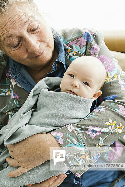 Grandmother holding newborn grandson (0-1 months)