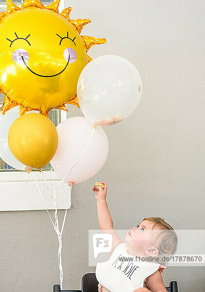 Baby girl (12-17 months) with balloons