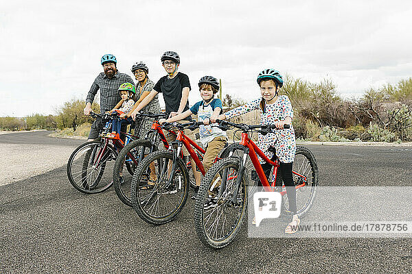 Family with children (2-3  8-9  14-15) biking together