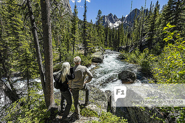 United States  Idaho  Stanley  Senior couple standing next to rushing stream near Sun Valley