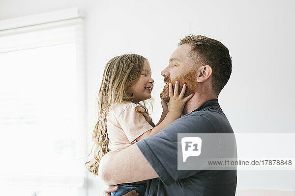 Father holding daughter (2-3)