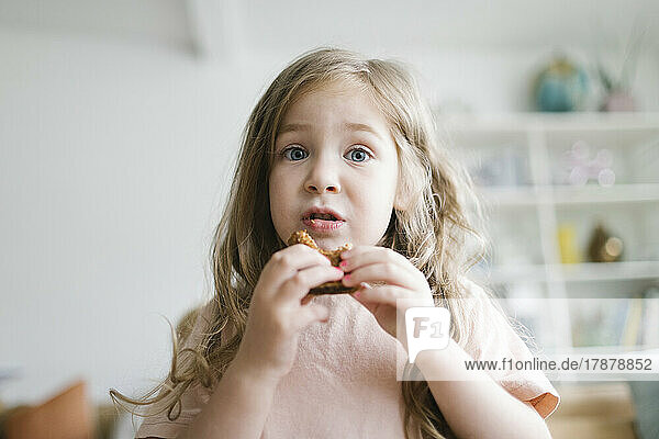 Girl (2-3) eating snack