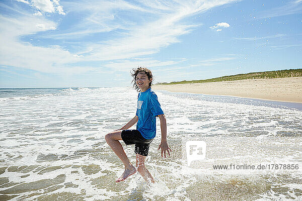 Smiling boy (10-11) playing in ocean