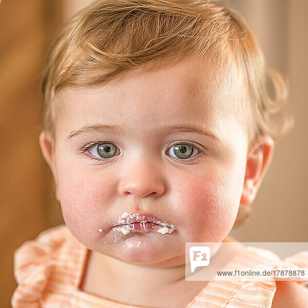 Portrait of baby girl (12-17 months) with icing around mouth