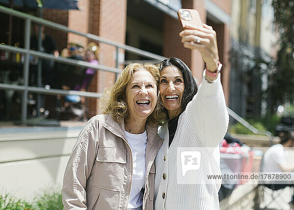 Smiling female friends taking selfie