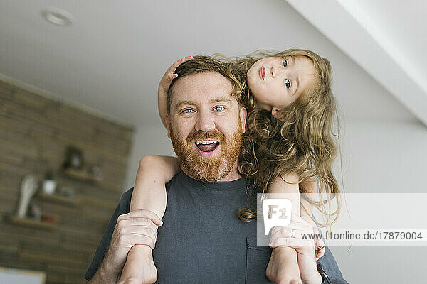 Father carrying daughter (2-3) on shoulders