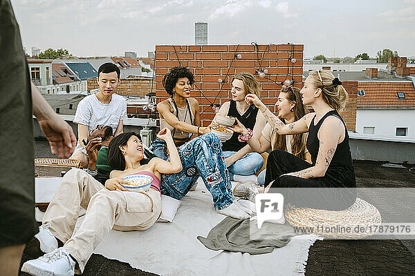 Happy multiracial friends enjoying party on rooftop