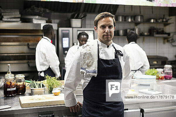 Portrait of confident chef standing in restaurant kitchen