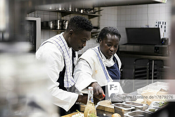 Male and female chefs preparing food at restaurant kitchen