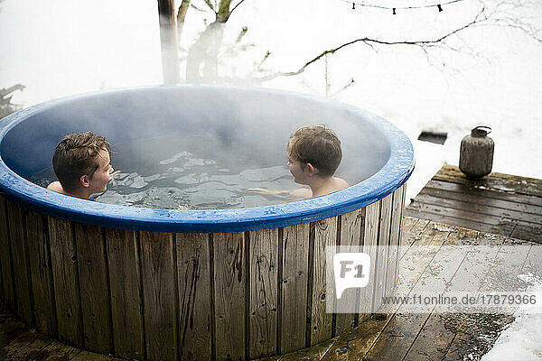 Boys enjoying in hot tub during winter