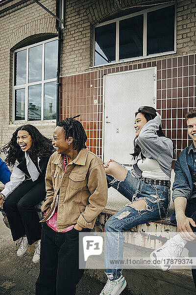 Glückliche multirassische junge Freunde vor dem Gebäude