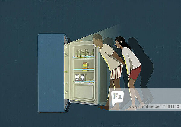 Couple standing at open refrigerator in kitchen at night