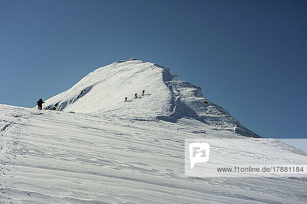 Mountain climbers climbing sunny  snowy mountain peak  Selkirk Mountains  Canada