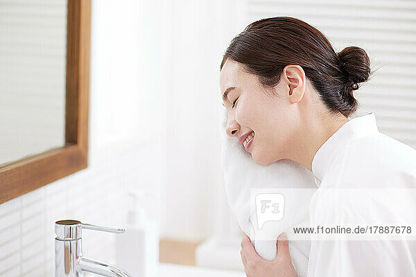 Japanische Frau wäscht ihr Gesicht zu Hause