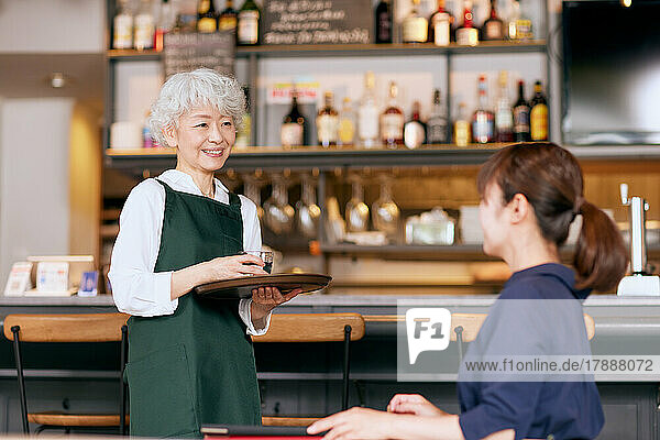 Japanische ältere Frau arbeitet in einem Restaurant