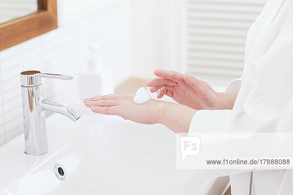 Japanerin beim Händewaschen mit schäumender Handseife