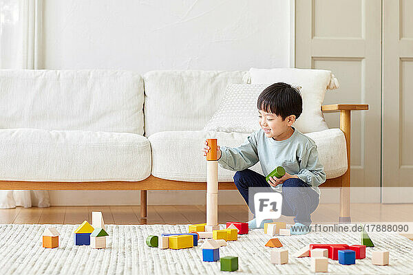 Japanisches Kind spielt zu Hause mit Spielzeug